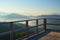 Early morning view from the terrace on mountains. Sunbeams falling on the balcony, silhouettes of mountain peaks and fog in the