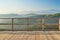 Early morning view from the wooden terrace on Carpathian mountain range. Sunbeams falling on the balcony, blue mountain peaks in