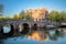 Early quiet morning in Amsterdam. Gentle sun shines the famous view of Amsterdam. Typical old houses and bridges