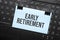 EARLY RETIREMENT inscription on white paper note on laptop keyboard. Closeup message