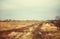 Early spring, dirt road, depressed rural landscape under a cloud