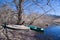 Early spring landscape with small old wooden selfmade fishing boats punt and bare trees on the bank of a river