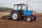 In the early,spring morning, tractor goes and pulls a plow,plowing a field before landing of crops.