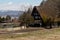 Early spring scenic landscape photograph of a traditional thatched roof house in rural Japan next to a rice paddy