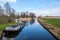 Early spring view on Giethoorn, Netherlands, a traditional Dutch village with canals. A typical low boat along the lawn in a