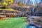 Early spring view of waterfall through jagged rocks into majestic waters