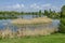 Early springtime green, dry reed or rush and house on a beauty lake in residential district Drujba