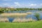 Early springtime green, dry reed or rush and house on a beauty lake in residential district Drujba