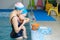 Early swimming coach training to swim baby in indoor pool