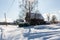 Early winter morning. Street in traditional Russian village in snowy frost winter