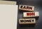 Earn More Money written on a wooden blocks on black. Business career concept
