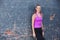 Earn your body. Portrait of a happy young woman working out next to a brick wall outside.