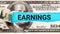 Earnings word written on with American Dollar-bills. The word Earnings on dollar usa background. Finance and money