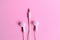 Earphone, white in ear headphones on a light pink background.