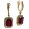 Earrings in yellow gold English lock with panels of red stone on a white background