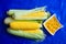 Ears of corn lie in the leaves and grains peeled nearby on a platter are a valuable food product for people and animal feed