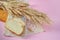 Ears of wheat and white bread rusks on a wooden board