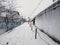 Earth is covered with snow, footpath on snow, icicles hanging on roof of old houses. Winter in Ukrainian village