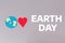 Earth Day. A felt-cut symbol of the planet earth and a red heart. Gray background with text. Flat lay. The concept of