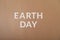 Earth Day white cardboard letters on a craft paper