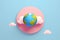 Earth floating in cloud against soft pink background, symbolizing planet's delicate balance and