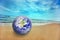 Earth globe on the beach