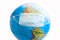 Earth globe with medical disposable face mask. COVID 19 or ecological disaster concept.  Planet Earth with