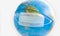 Earth globe with medical disposable face mask. COVID 19 or ecological disaster concept.  Planet Earth with