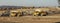 Earth moving equipment at a construction grading site with other tractors lined up in the background