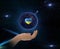 Earth  with Ukraine flag color blue and yellow in heart symbol in hands on front blue starry sky nebula hold world peace conc