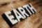 EARTH word made with building blocks on wooden board