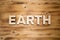 EARTH word made with building blocks on wooden board