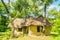 Earthen house under shade of trees. An earth house, also known as earth berm, earth sheltered home, or eco-house is an architectur