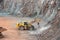 Earthmover in a open pit mine quarry. porphyry rock