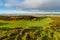 Eary morning light reveals a lush green golf course with a rolling landscape of grass and fields in Ireland