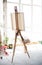 Easel with canvas standing in empty artistic studio