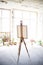 Easel with canvas standing in empty artistic studio