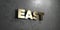 East - Gold sign mounted on glossy marble wall - 3D rendered royalty free stock illustration