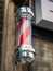 An East London barber shop pole in red & white spiral stripes.