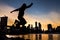 East River and Brooklyn Bridge dusk with a man jumping