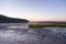 East view of the deserted Baie-St-Paul beach and jetty at low tide seen during a summer sunrise