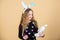 Easter activities for children. Holiday bunny little girl with long bunny ears. Child cute bunny costume. Kid hold