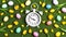 Easter alarm clock with colorful eggs and tulips on a green grass background