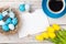 Easter background with blue and white eggs in nest, yellow tulip