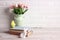 Easter background with books, chicken, rabbit and tulips against a white brick wall