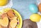 Easter background with colored eggs, holiday homemade cookies and empty place for text