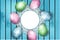Easter background, colorful painted eggs laying on blue wooden board