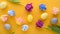 Easter background of purple and pink tulips, pastel yellow, blue eggs on yellow background