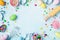 Easter baking background with rolling pin, whisk, decorative eggs, cookie cutters, candy and colorful confetti on kitchen table