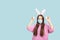 Easter banner with copy space, teen girl with Easter eggs in a medical mask on a blue background